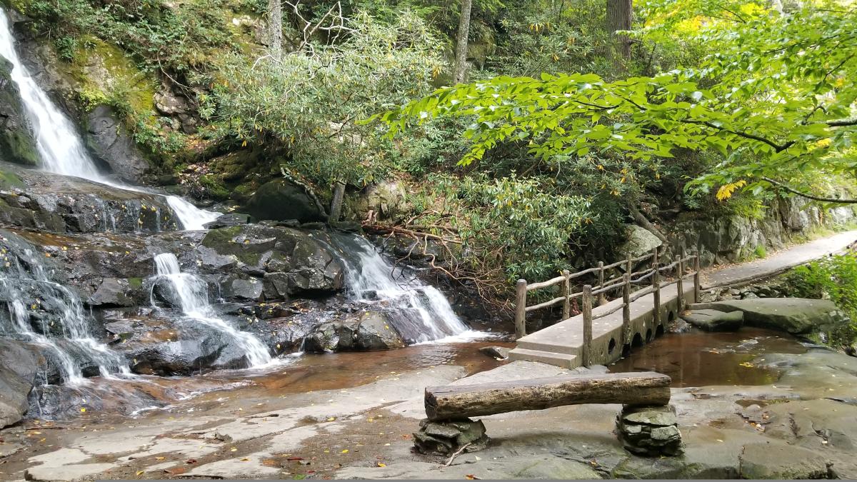 Historic stone bridge crossing Laurel Falls with mist rising